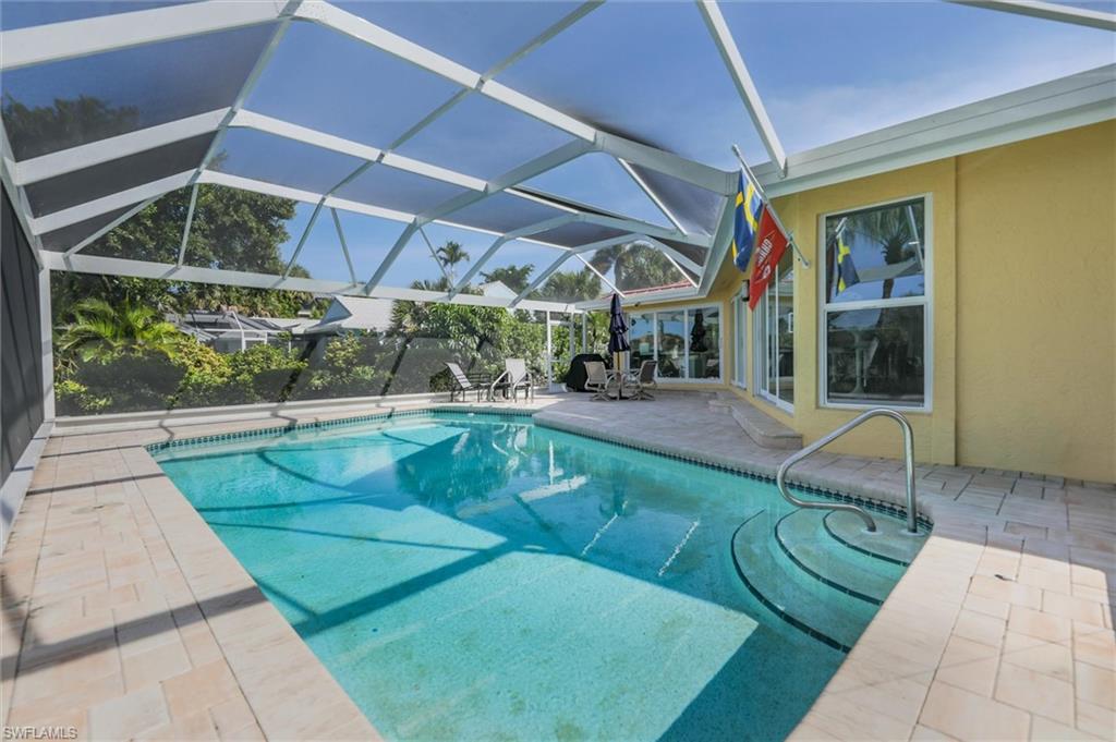 Outdoor pool with a patio, screen enclosure, and a sunroom
