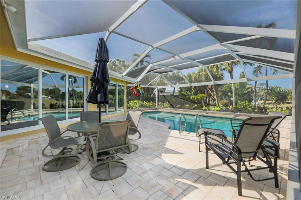 Outdoor pool featuring a sunroom, a patio area, and a lanai