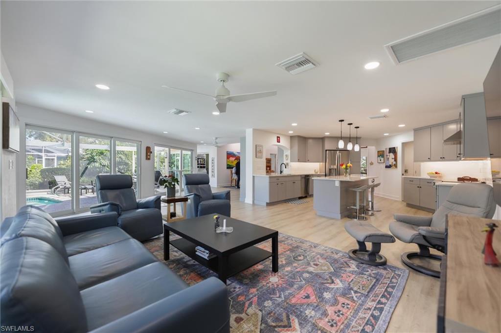 Living room featuring light wood-type flooring, a ceiling fan, and recessed lighting