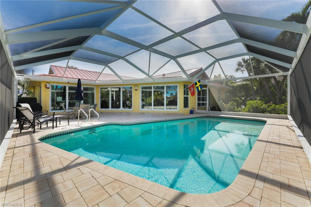 Outdoor pool featuring a sunroom, a patio, and a lanai
