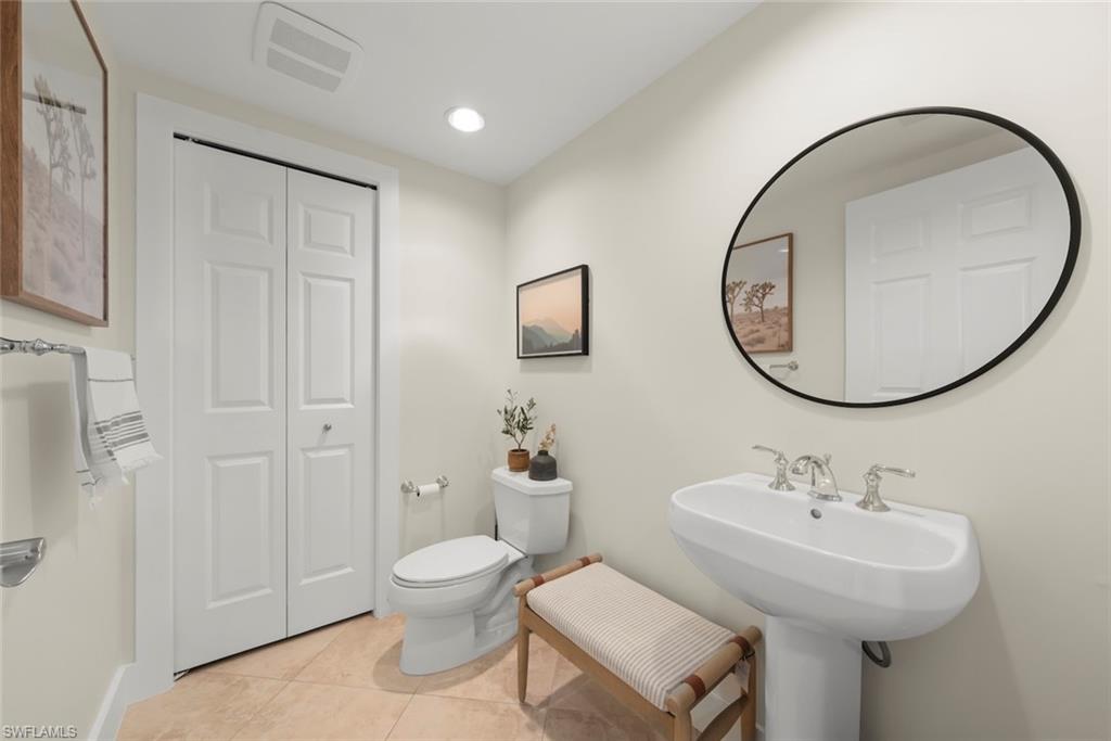 Half bathroom with light tile patterned flooring, a closet, and recessed lighting