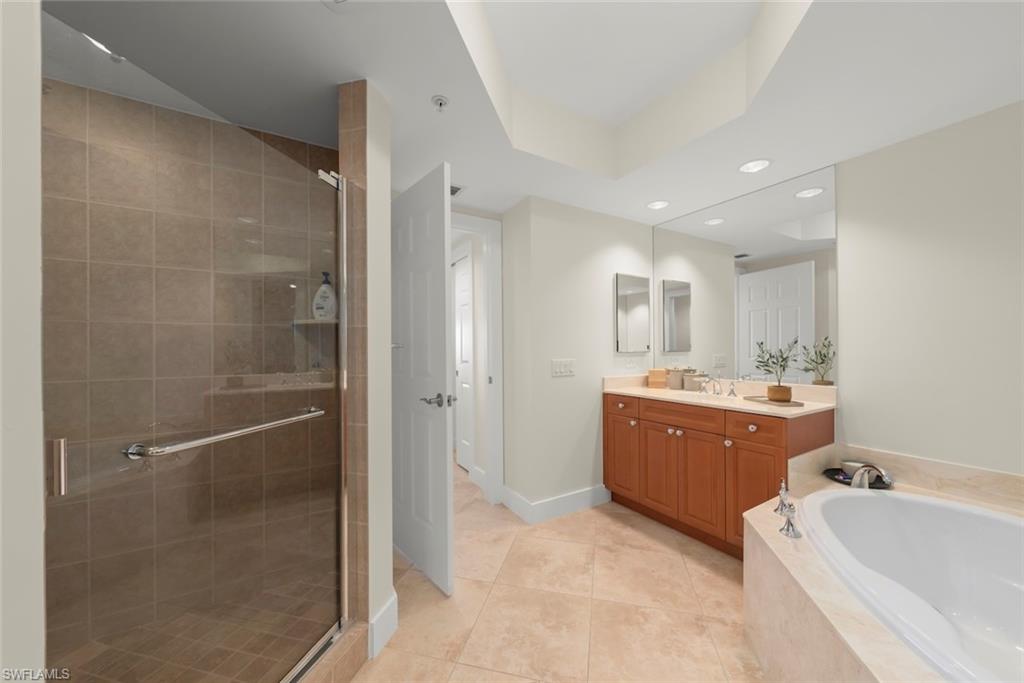Bathroom with vanity, a bath, a stall shower, light tile patterned floors, and recessed lighting