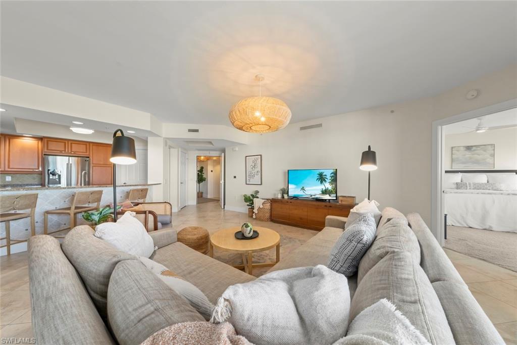 Living room with light tile patterned floors, ceiling fan, and recessed lighting