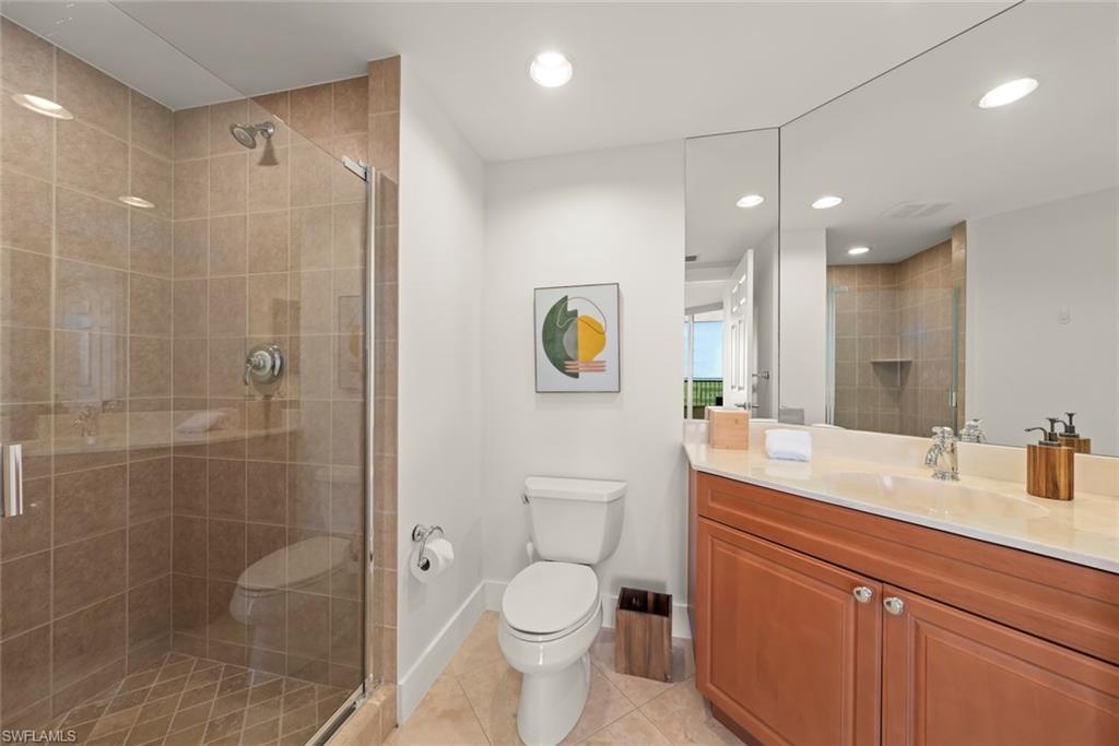Bathroom with vanity, a stall shower, light tile patterned flooring, and recessed lighting