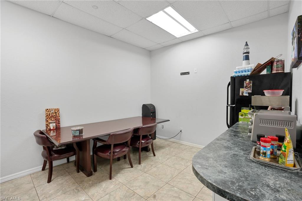 Dining space featuring a drop ceiling and light tile patterned floors