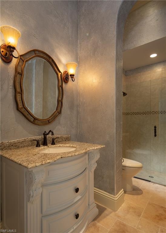 Full bathroom with vanity, a stall shower, and a textured wall