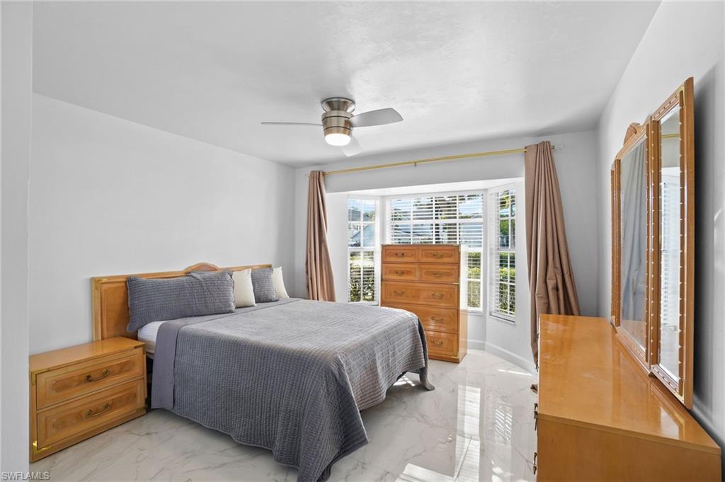 Bedroom with light marble finish flooring and ceiling fan