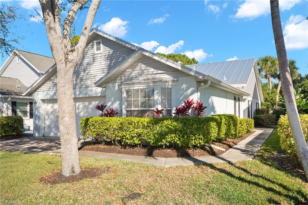 View of front of home with a front yard and an attached garage