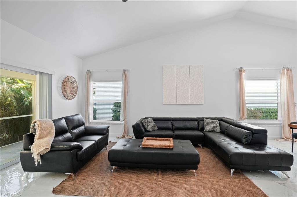 Living area with marble tiled flooring and vaulted ceiling
