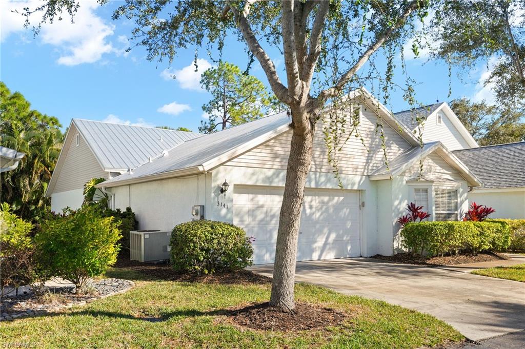 View of property exterior featuring a garage, driveway, and stucco siding