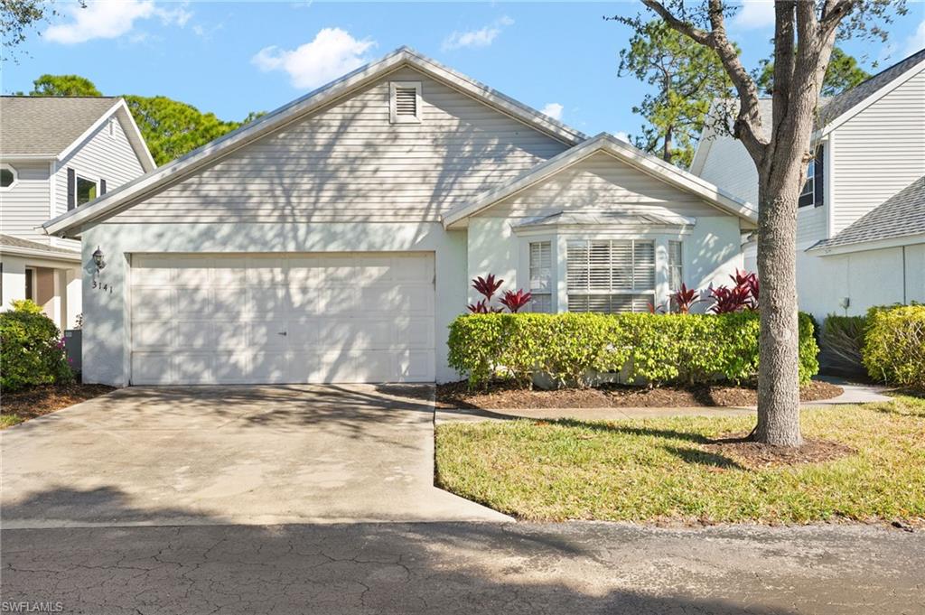 View of front of property featuring driveway, a garage, stucco siding, and a front yard
