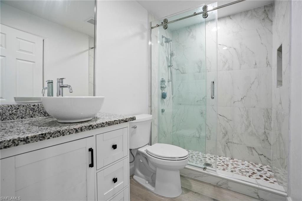 Full bath with vanity and a marble finish shower