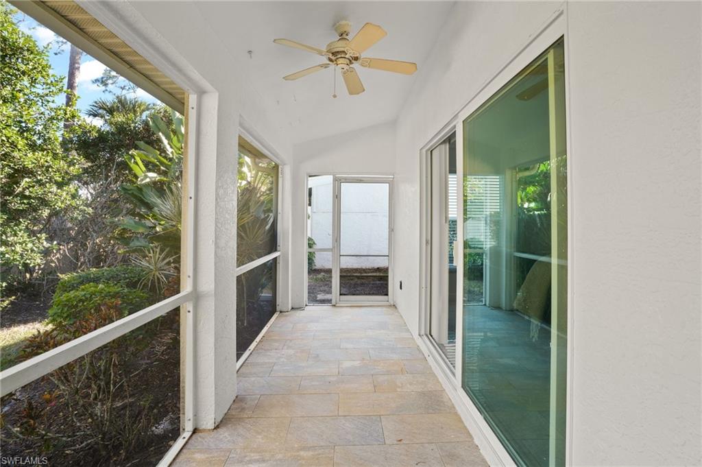 Unfurnished sunroom featuring stone tile floors and vaulted ceiling
