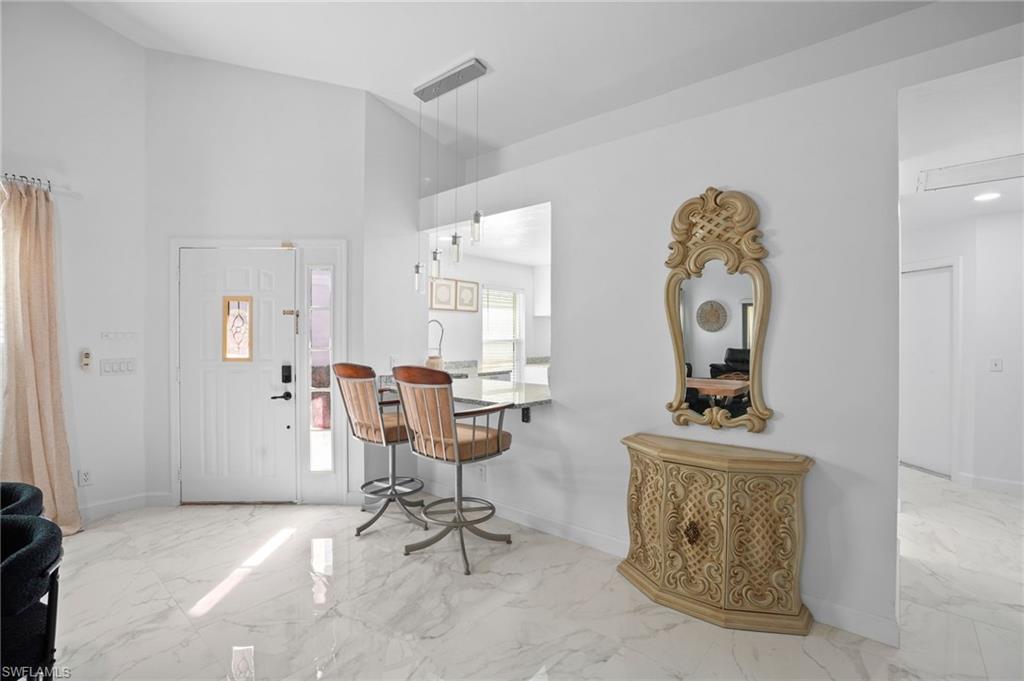 Foyer entrance with light marble finish flooring and high vaulted ceiling