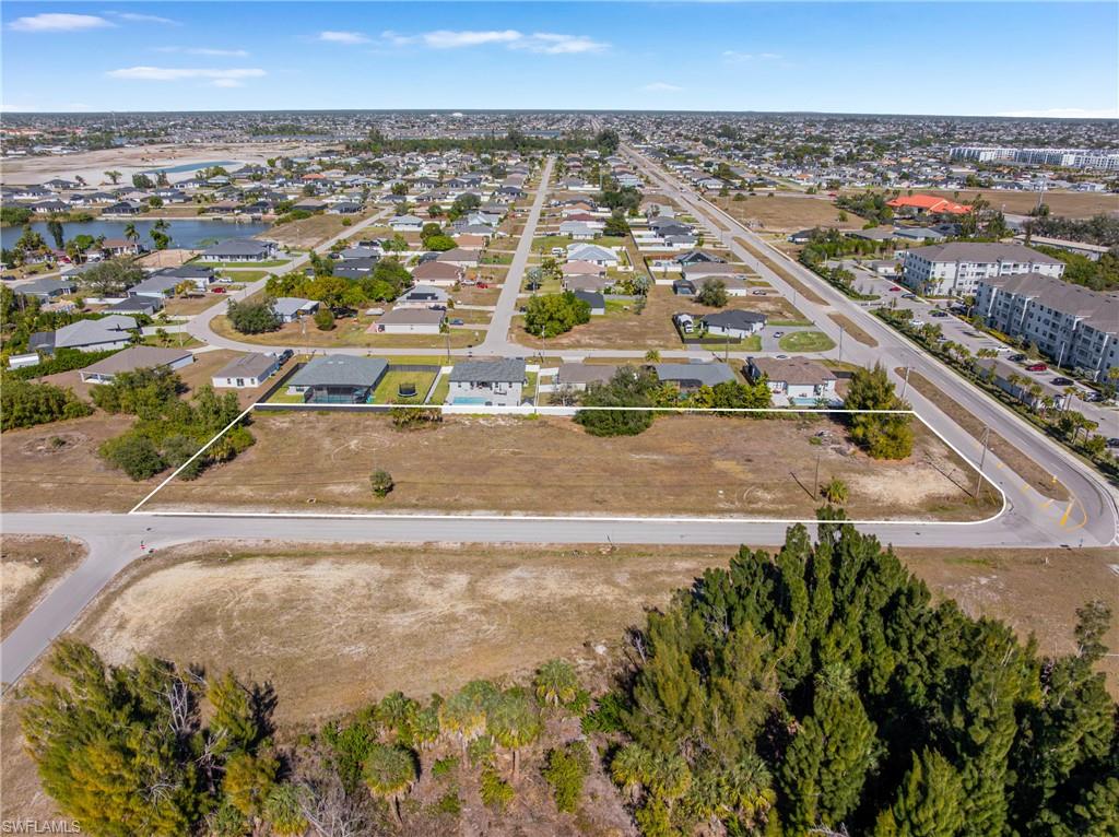 Aerial perspective of suburban area featuring property parcel outlined and a nearby body of water