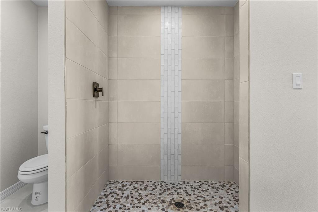 Bathroom featuring a stall shower and a textured wall
