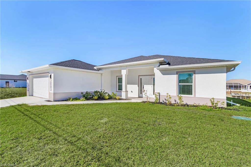 Prairie-style house featuring a front lawn, stucco siding, a porch, and concrete driveway