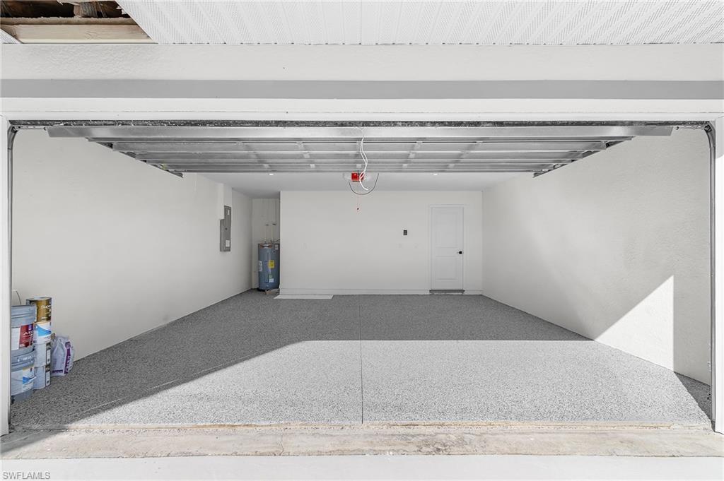 Garage featuring water heater and electric panel