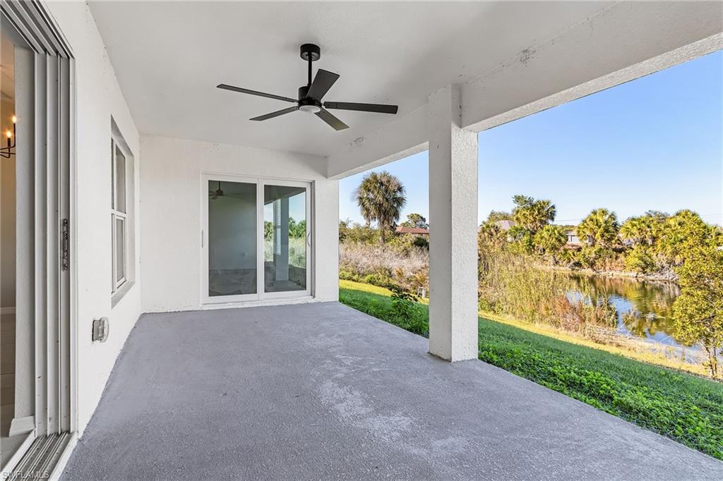 View of patio with ceiling fan and a water view