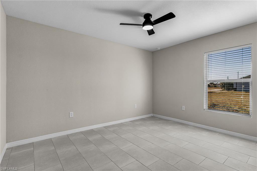 Empty room with baseboards and ceiling fan