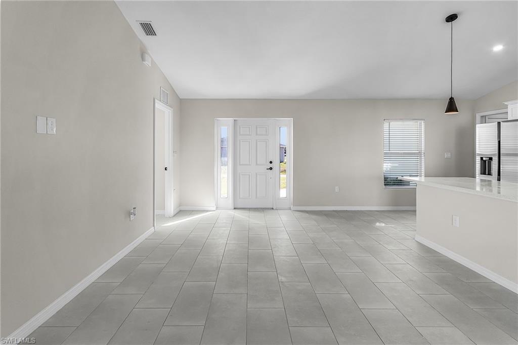 Foyer with baseboards and vaulted ceiling