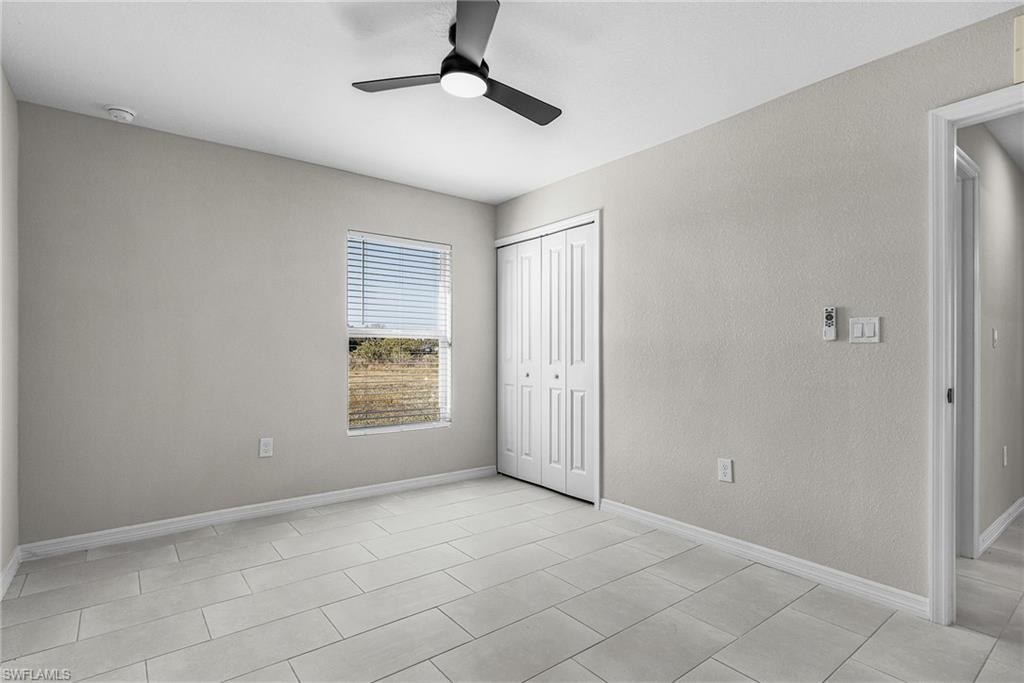 Unfurnished bedroom featuring a ceiling fan, a closet, and a textured wall