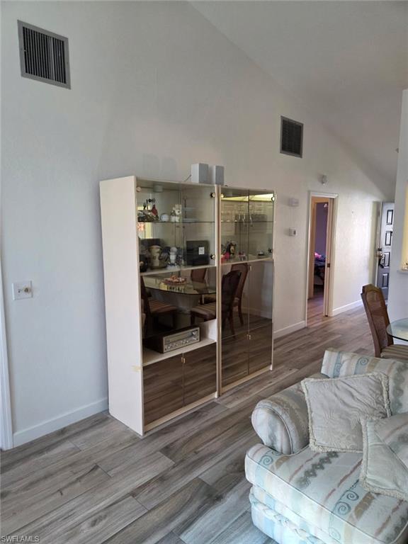 Living area with wood finished floors and high vaulted ceiling
