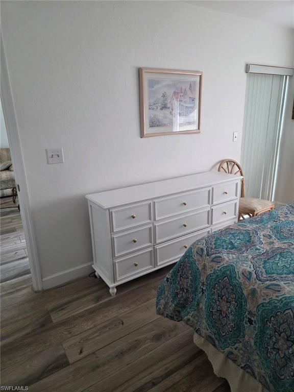Bedroom featuring dark wood finished floors and baseboards