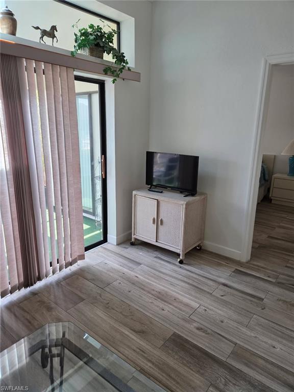 Unfurnished living room with light wood-style flooring and baseboards