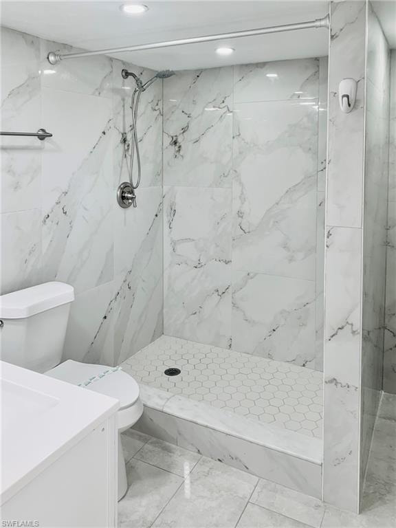 Bathroom with a marble finish shower and vanity