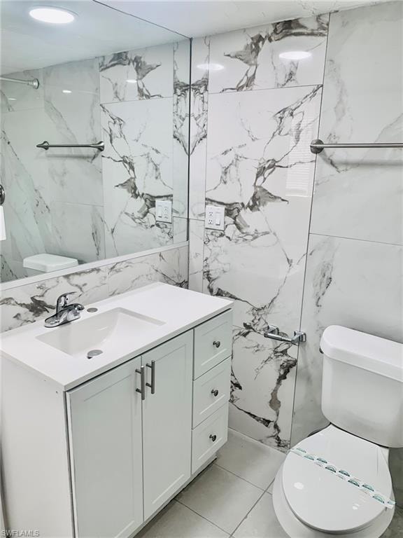 Half bathroom with vanity, tile walls, light tile patterned floors, and stone wall