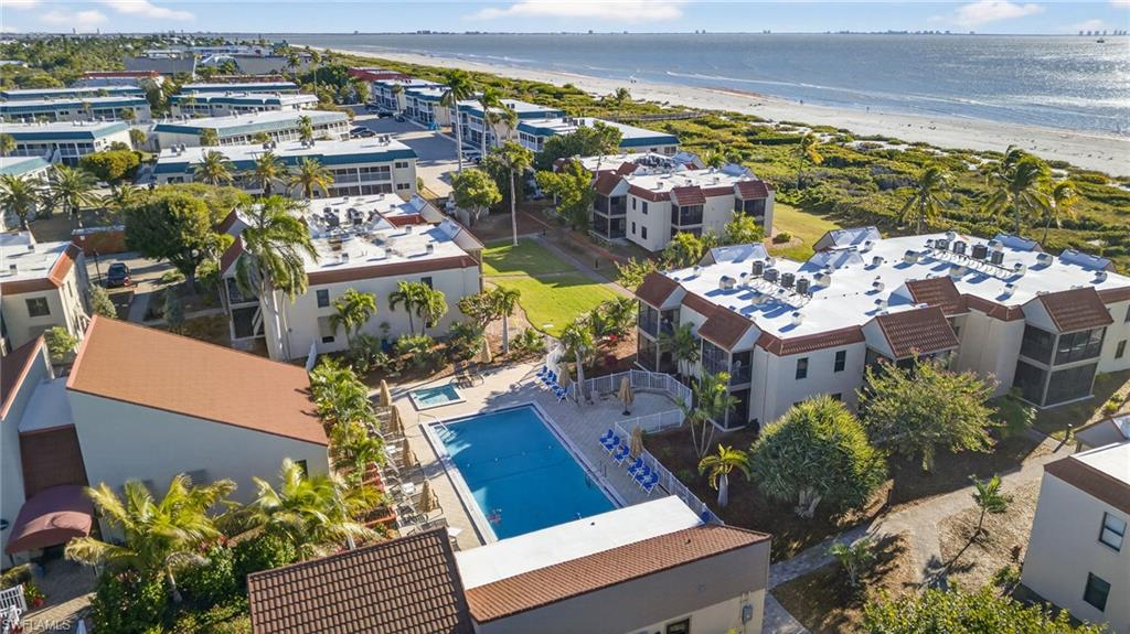Bird's eye view of waterfront with a beach and a pool area