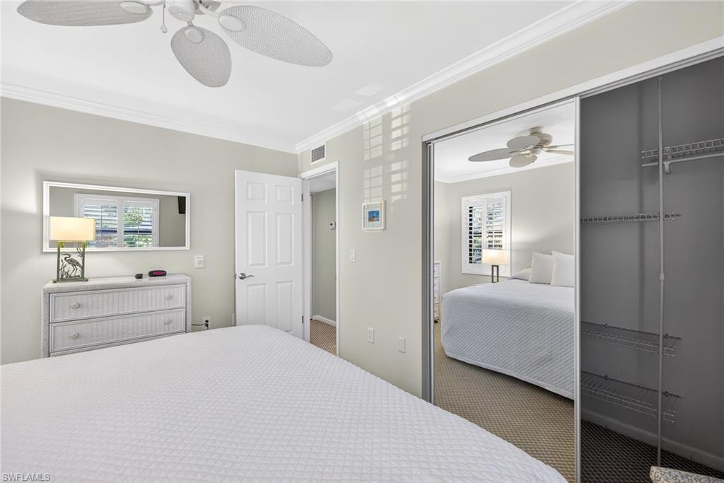 Carpeted bedroom with crown molding and ceiling fan