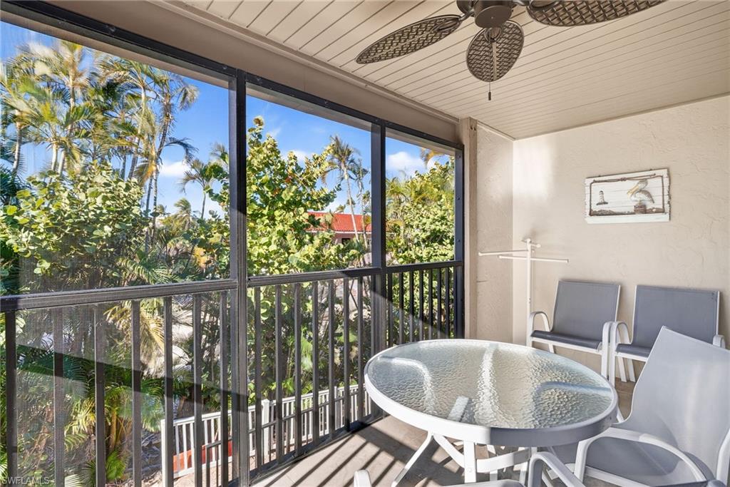 Sunroom / solarium featuring a balcony, a ceiling fan, wood ceiling, a textured wall, and outdoor dining space