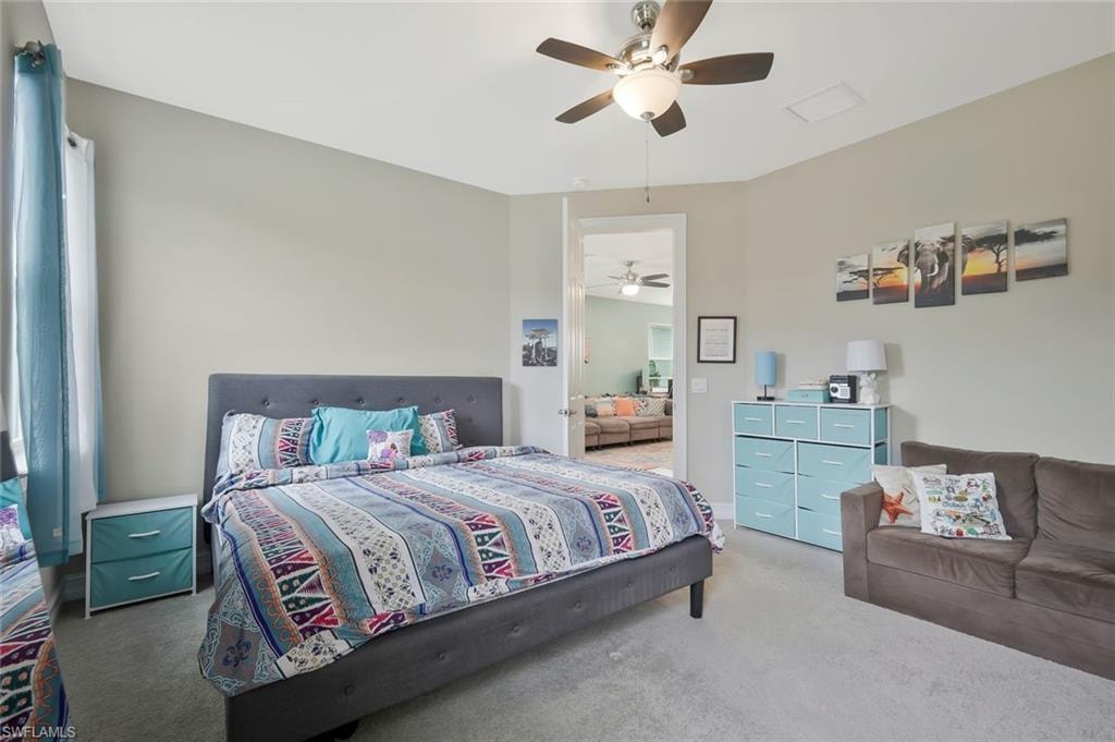 Carpeted bedroom with a ceiling fan