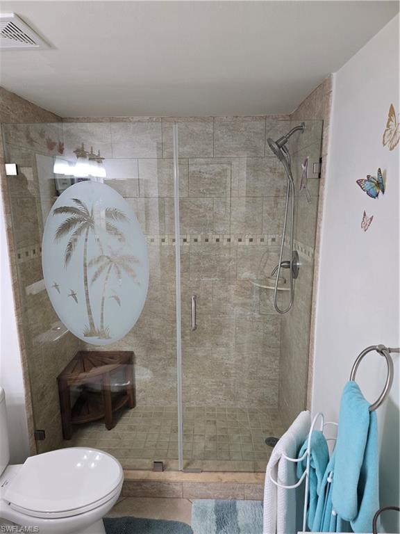 Bathroom featuring visible vents, toilet, and a shower stall
