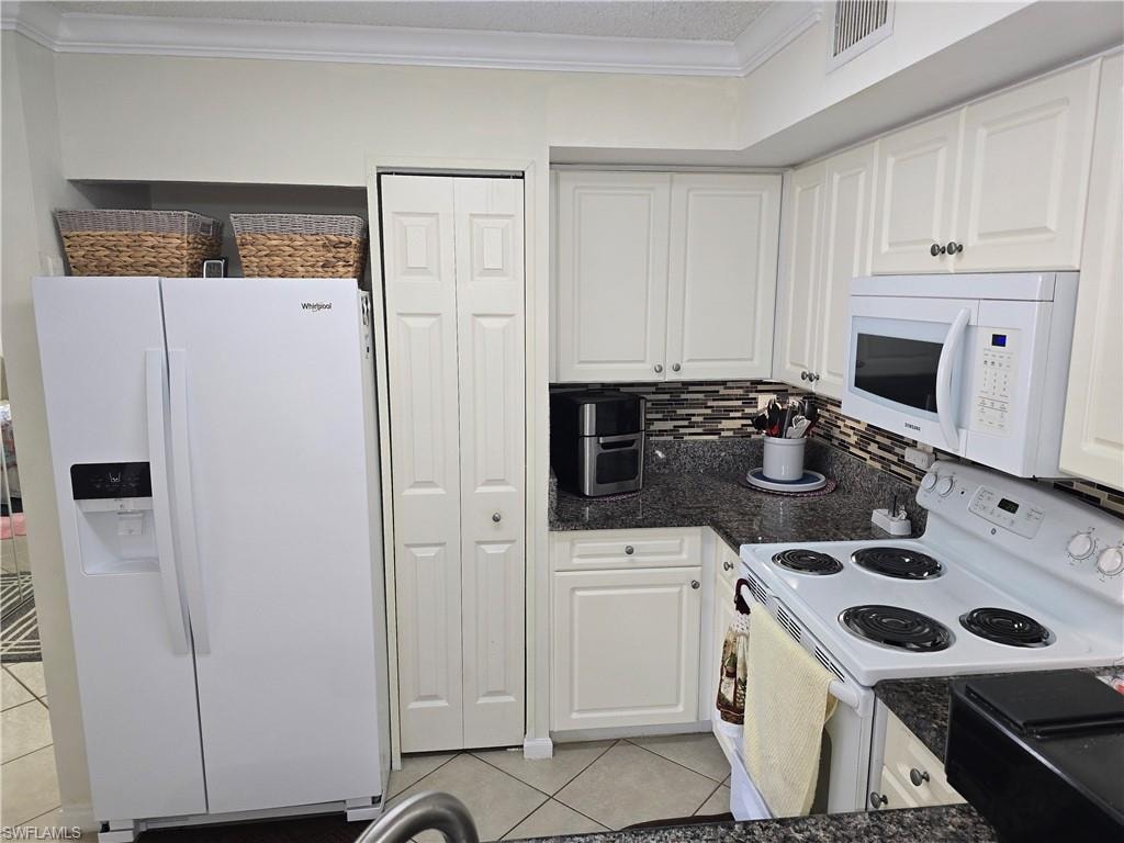 Kitchen featuring visible vents, ornamental molding, white appliances, white cabinets, and light tile patterned floors