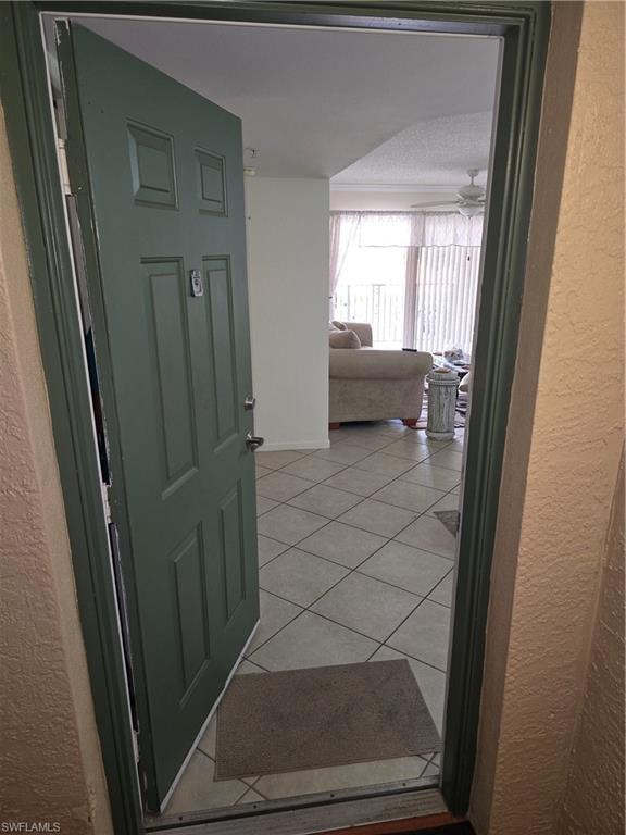 Corridor featuring a textured wall and light tile patterned flooring