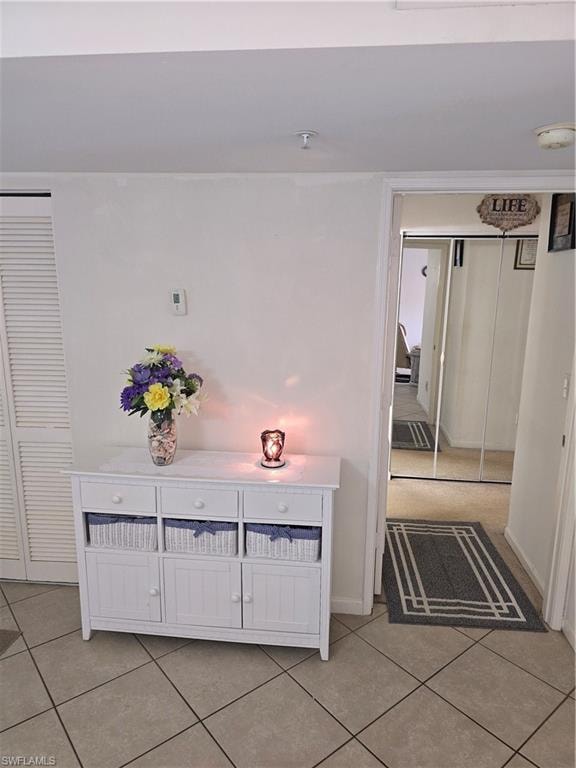 Corridor featuring baseboards and light tile patterned floors