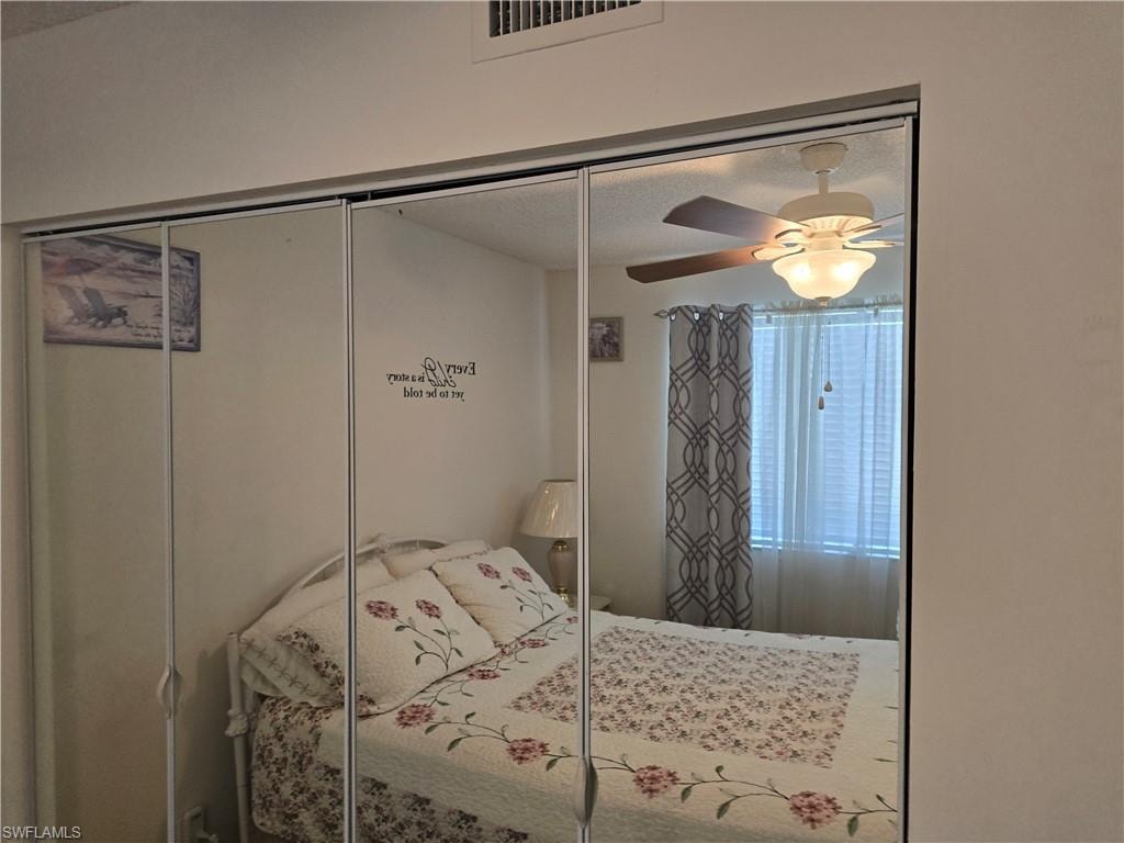 Bedroom featuring ceiling fan, a closet, and visible vents
