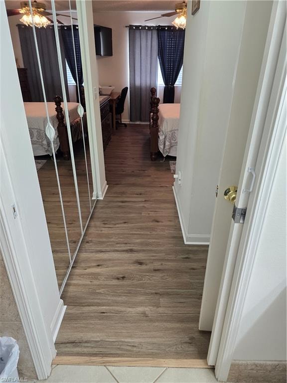 Corridor with light wood-style flooring and baseboards