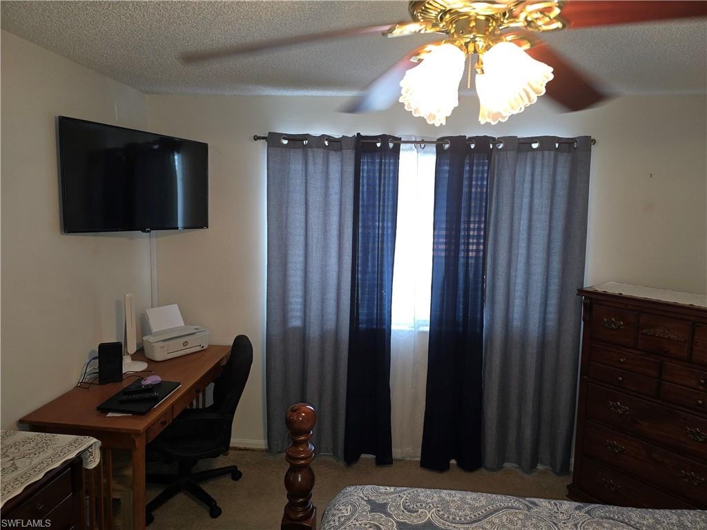 Bedroom featuring light colored carpet, a textured ceiling, and ceiling fan