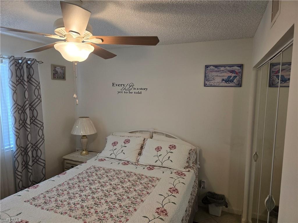 Bedroom with a closet, a textured ceiling, and visible vents