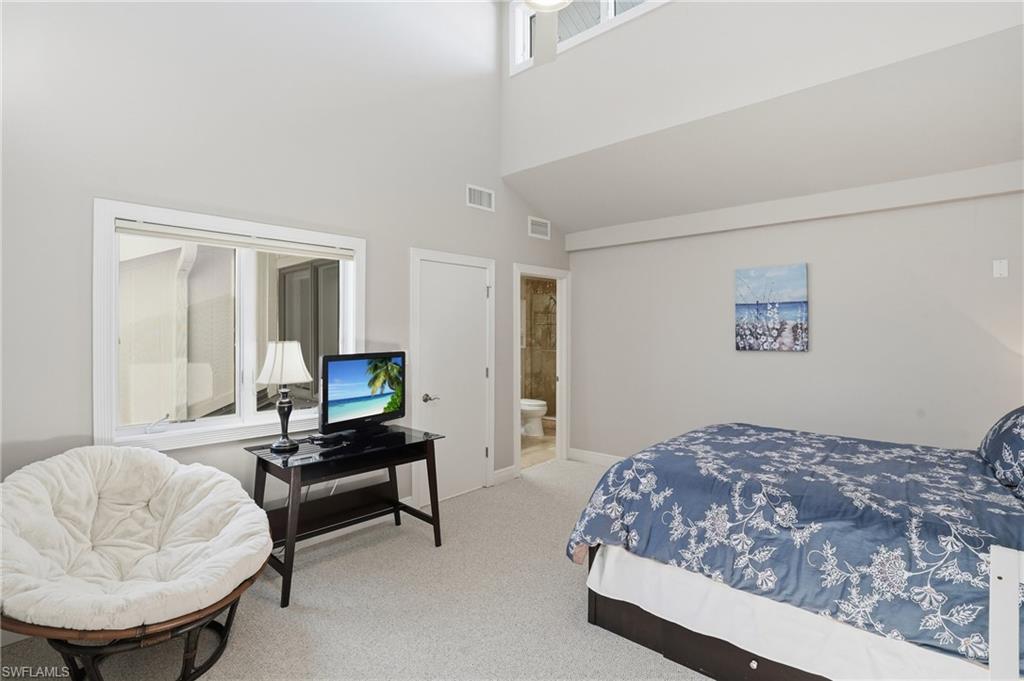 Bedroom featuring carpet flooring, a high ceiling, and ensuite bathroom