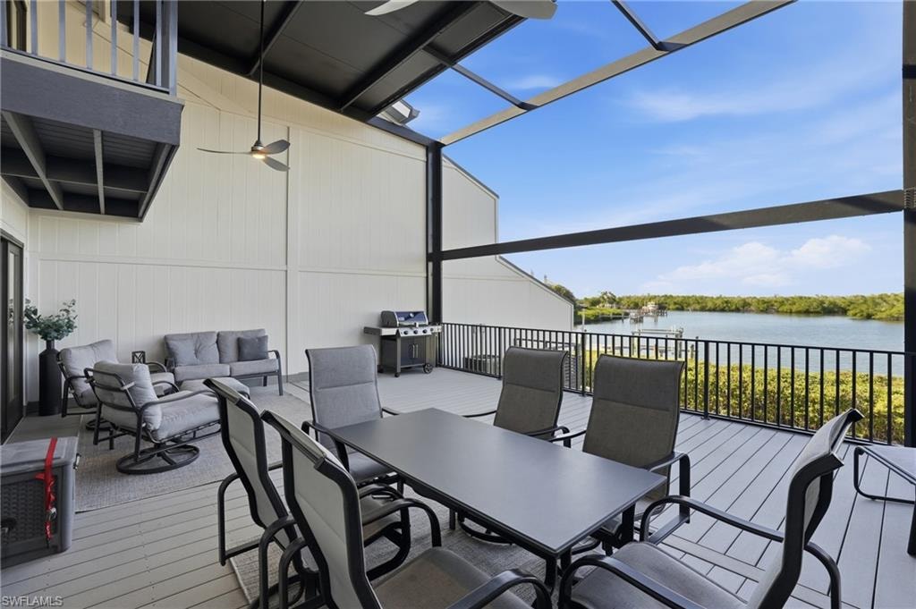 Wooden deck featuring an outdoor hangout area, a water view, grilling area, outdoor dining area, and a sunroom