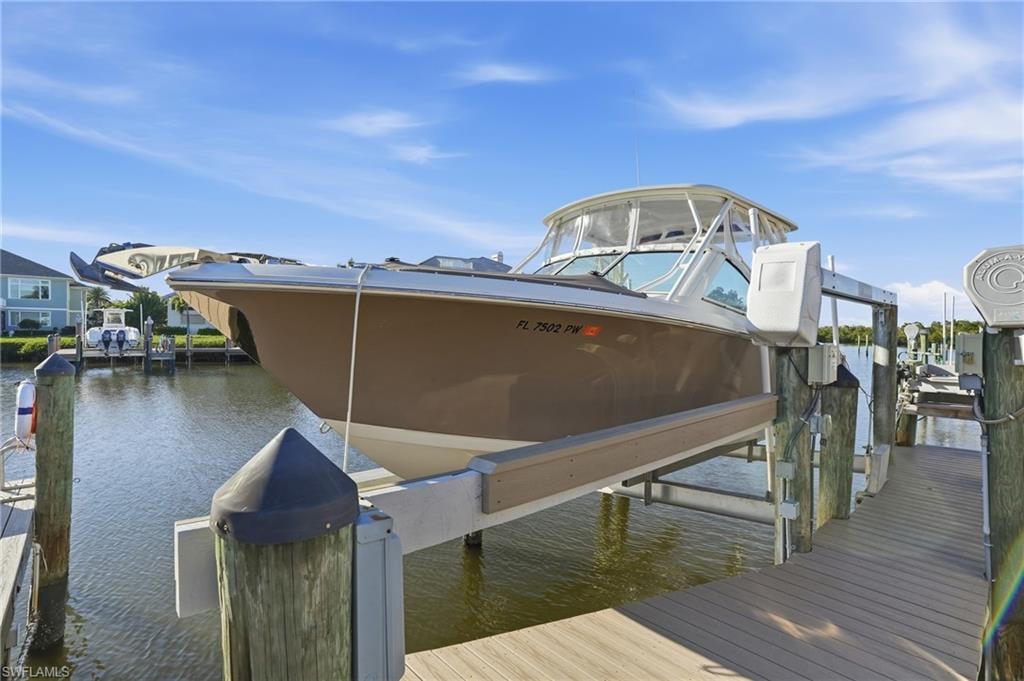 Dock area featuring boat lift and a water view