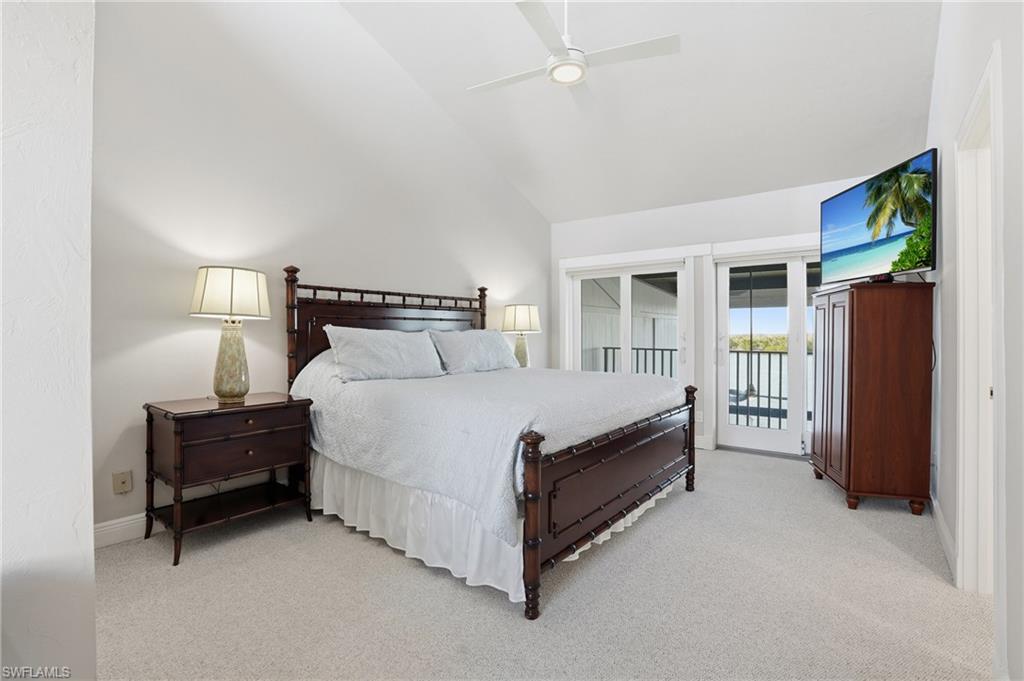 Bedroom featuring access to outside, high vaulted ceiling, light colored carpet, and a ceiling fan