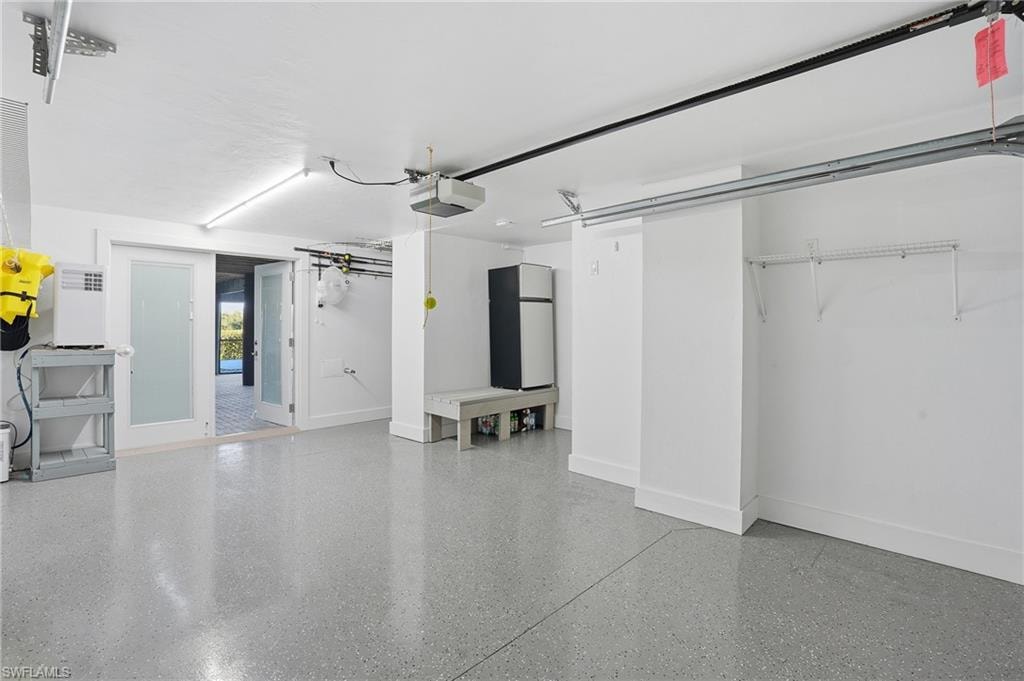 Garage with freestanding refrigerator and a garage door opener