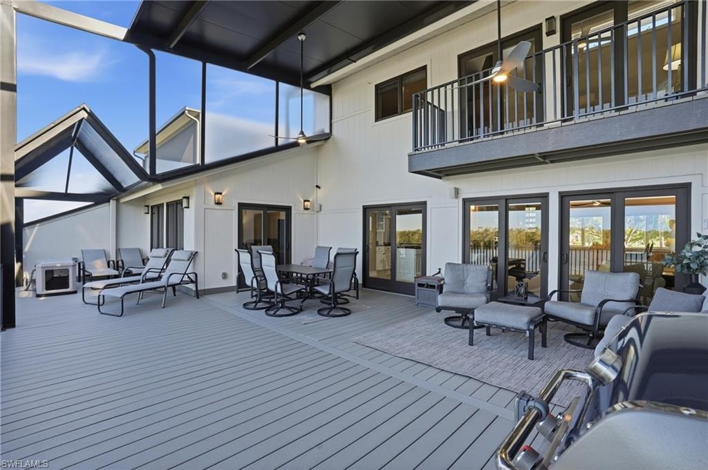 Deck featuring outdoor dining space, outdoor lounge area, and a sunroom