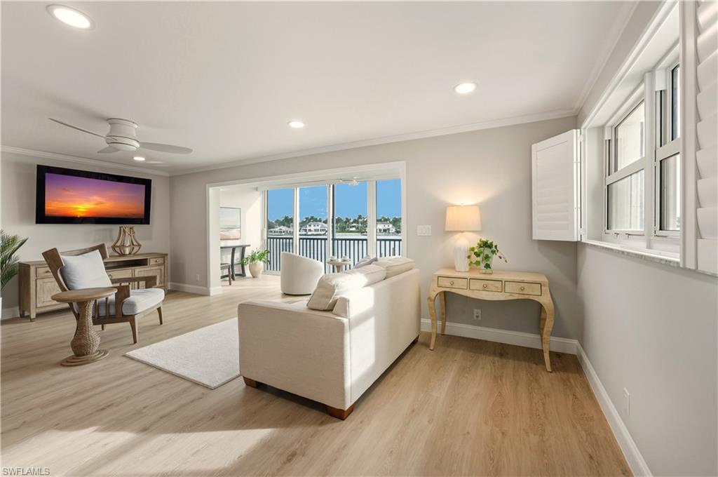 Living area featuring light vinyl flooring, recessed lighting, crown molding, and a ceiling fan